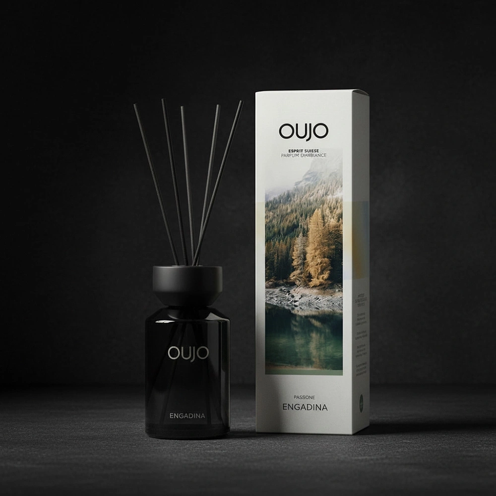 A black reed diffuser bottle with reeds and a box with a mountain landscape.