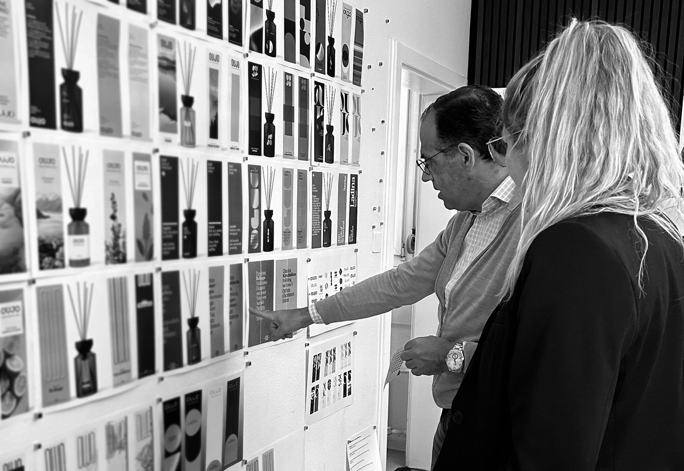 Man and woman look at a wall with many product packaging designs.