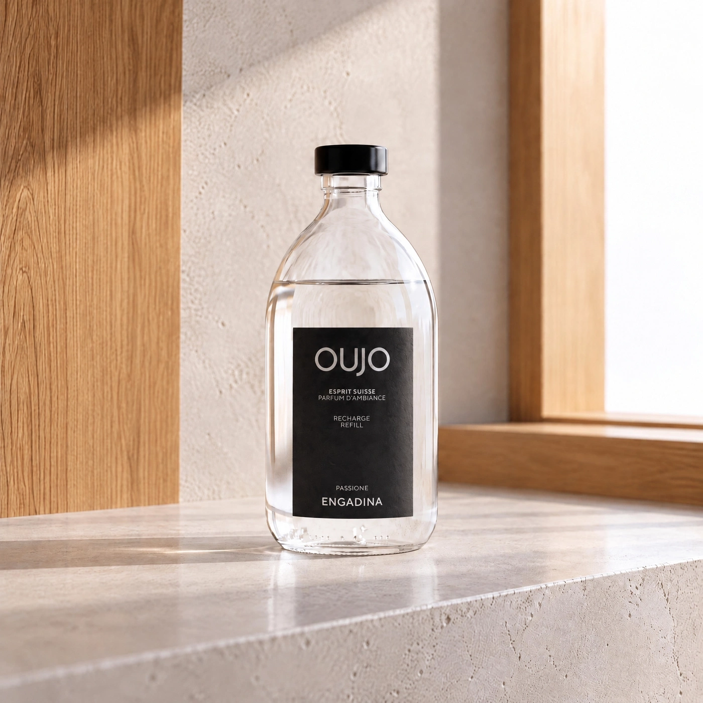 A clear glass bottle with a black label and cap rests on a stone surface.