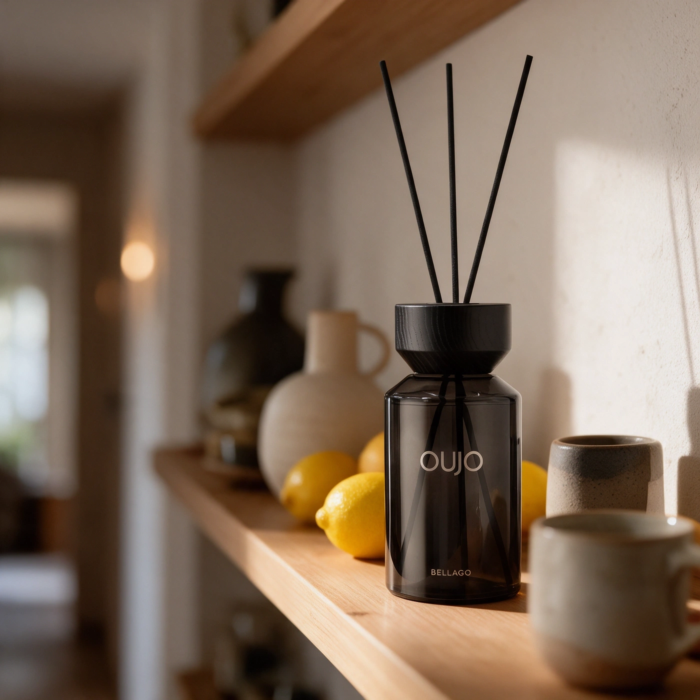 A diffuser with lemons and cups on a shelf.