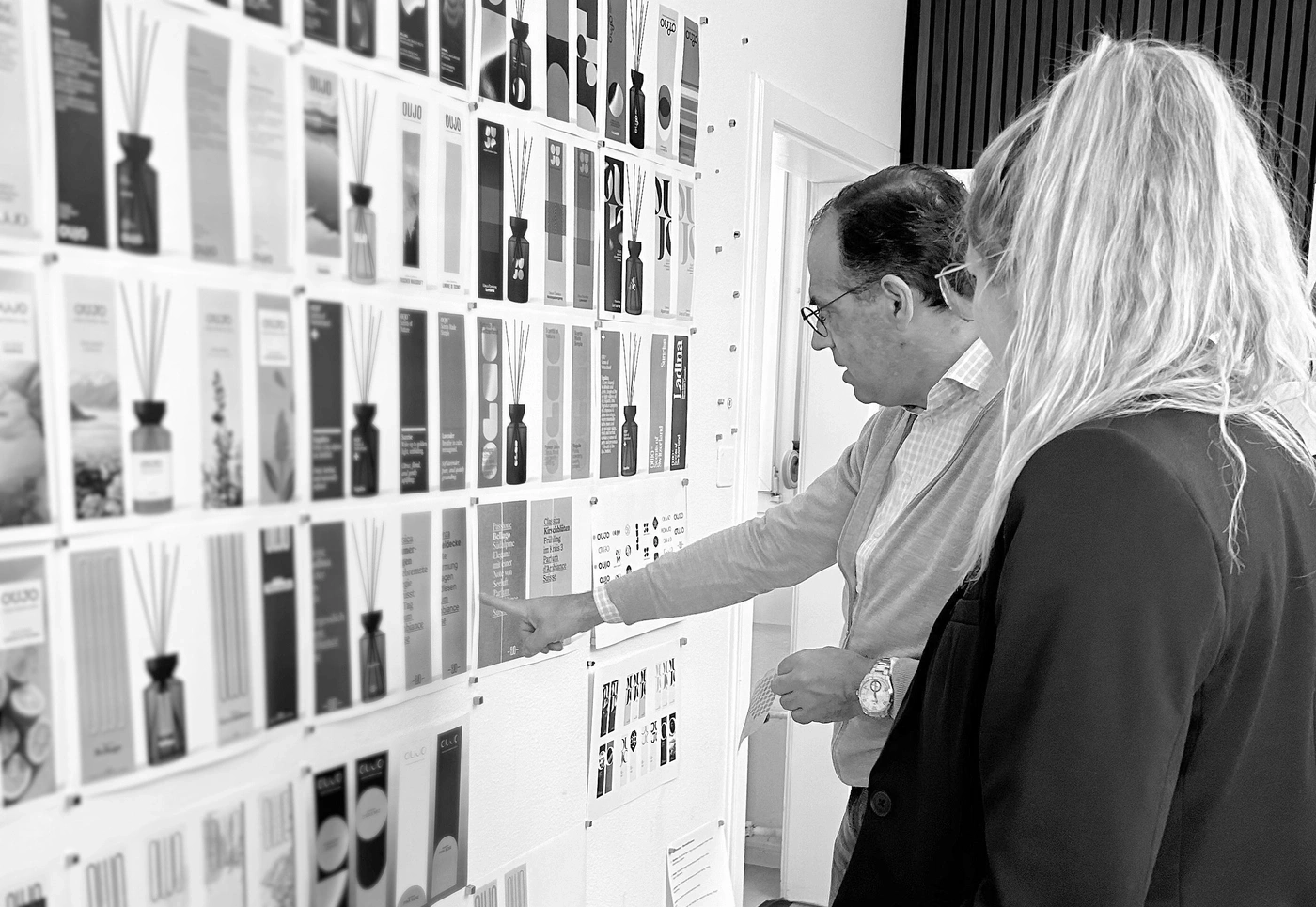 Mann und Frau betrachten Duftstäbchen-Designs an einer Wand.