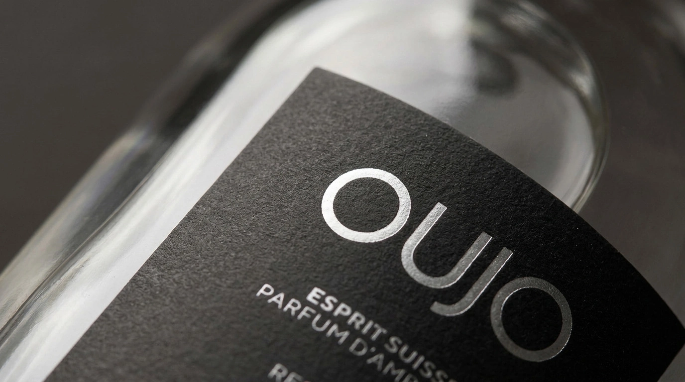 Close-up of a bottle label reading 'OUJO' in silver text.
