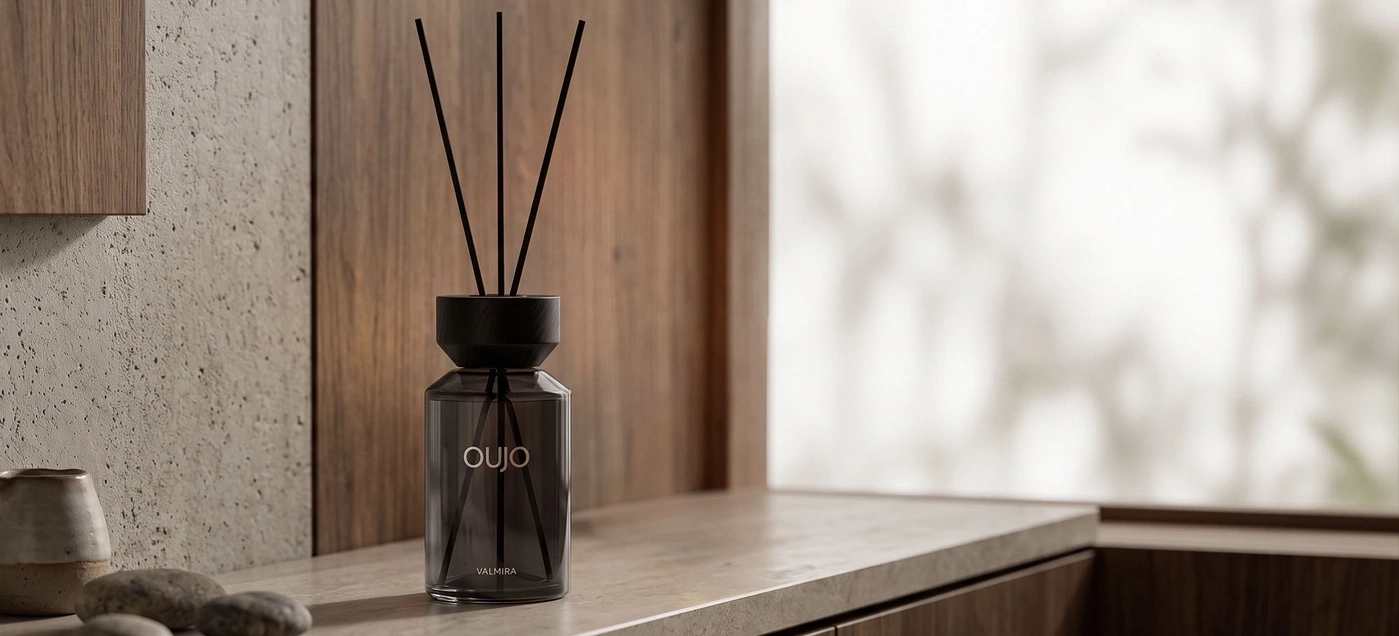 A diffuser with scented sticks sits on a stone shelf.